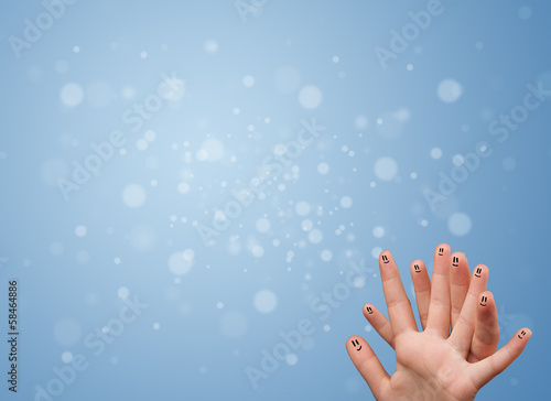 Happy finger smileys with empty blue bokeh background