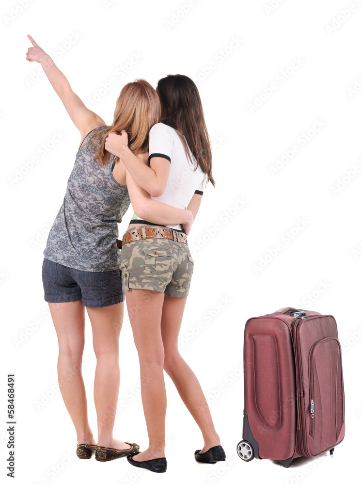 Two young women traveling with suitcas rear view. Two young women traveling with suitcas rear view.