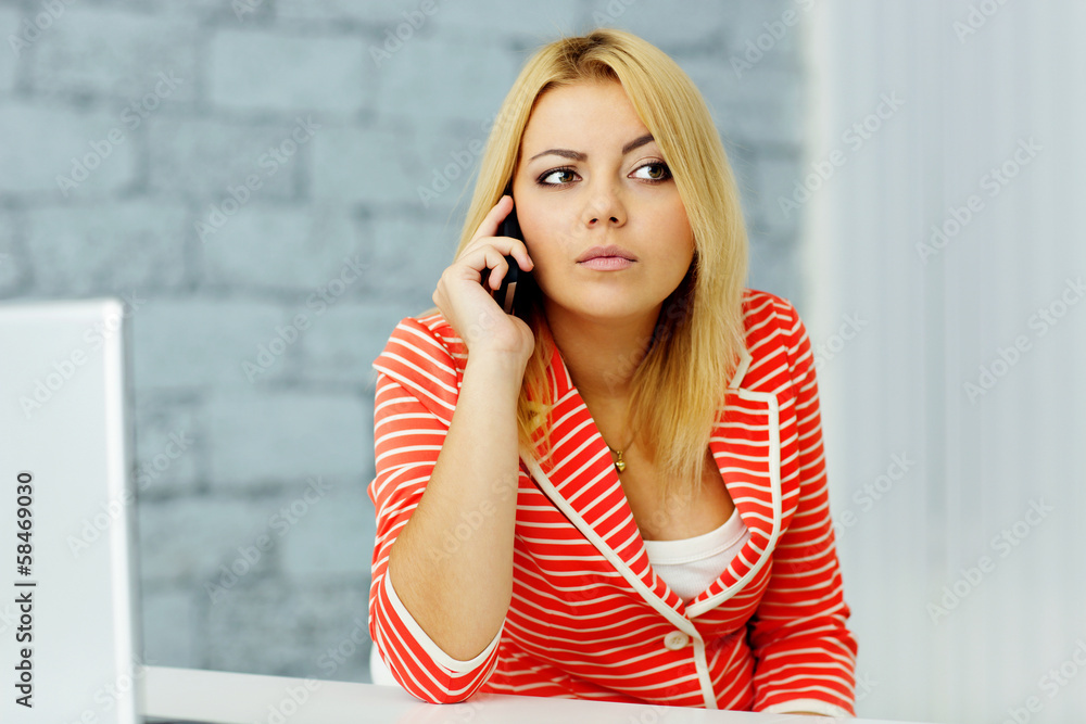Fototapeta premium Young businesswoman talking on phone