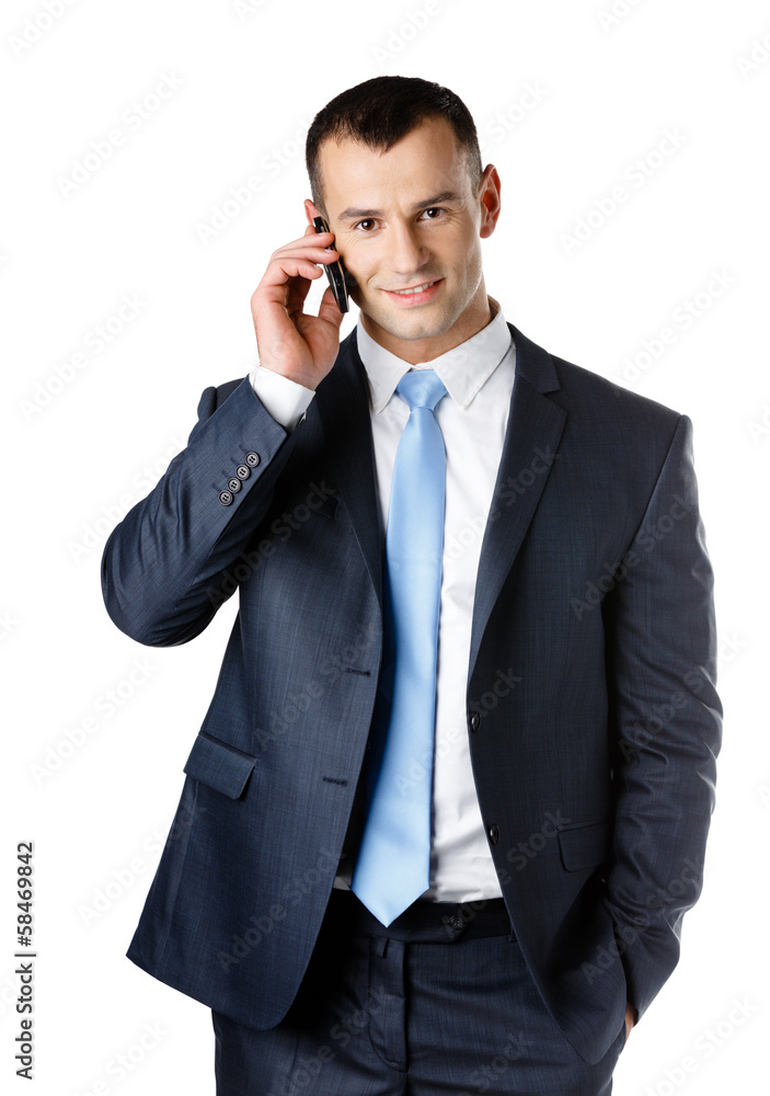 Businessman in suit and blue tie talking on phone Businessman in suit and blue tie talking on phone
