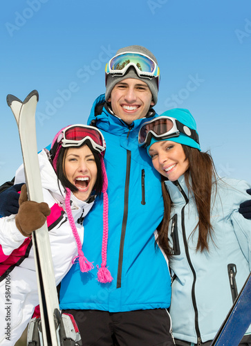 Half-length portrait of group of hugging skier friends