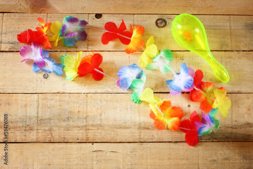 Necklace of bright colorful flowers lei on wood background