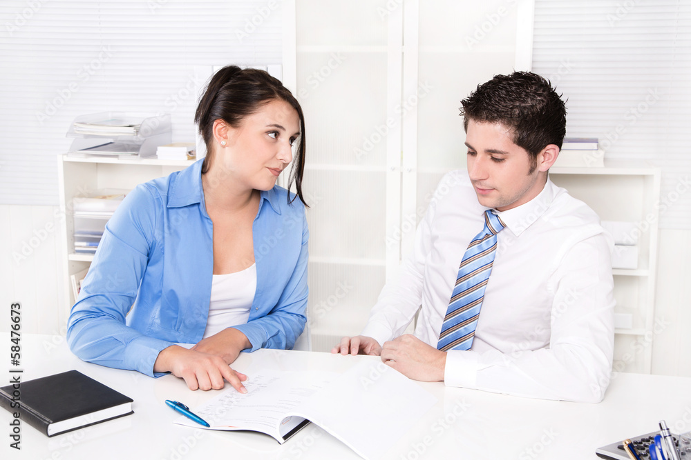 Fototapeta premium Two caucasian business people working at office.