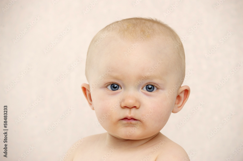 Baby looking at the camera on a peach background Baby looking at the camera on a peach background