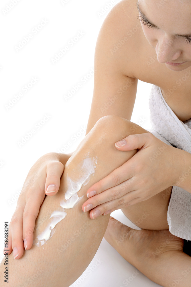 Fototapeta premium Frau cremt Beine mit Hautcreme ein