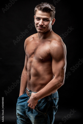 young muscular man on dark background