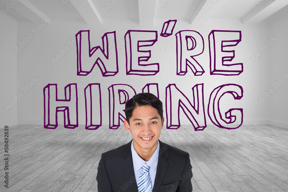 Businessman smiling in front of were hiring text Businessman smiling in front of were hiring text
