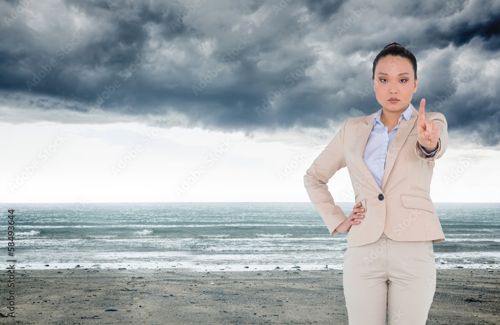 Composite image of unsmiling asian businesswoman pointing Composite image of unsmiling asian businesswoman pointing
