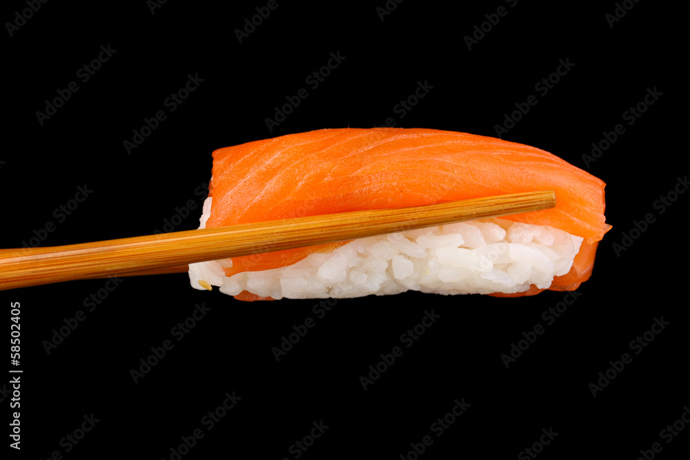 holding sushi with chopsticks isolated on black holding sushi with chopsticks isolated on black