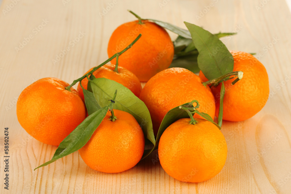 Sweet tangerines with leaves, on wooden background Sweet tangerines with leaves, on wooden background