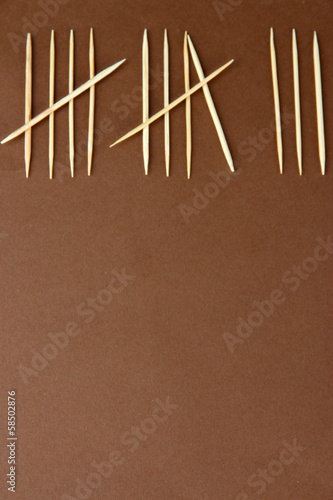 Toothpicks - counting days concept on brown background