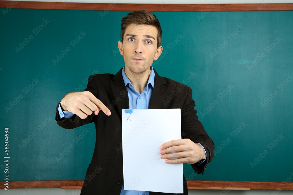 Young teacher near chalkboard in school classroom Young teacher near chalkboard in school classroom