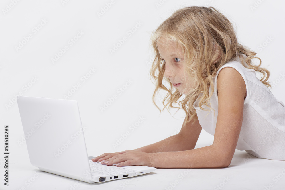 Beautiful blonde little girl with netbook, white background Beautiful blonde little girl with netbook, white background