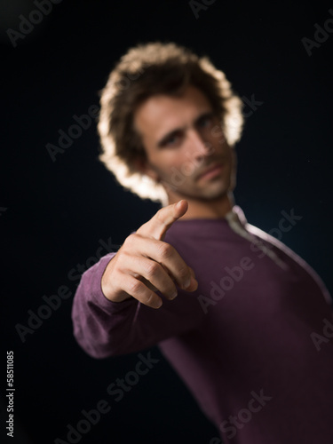 man in purple sweater gestures pointing finger