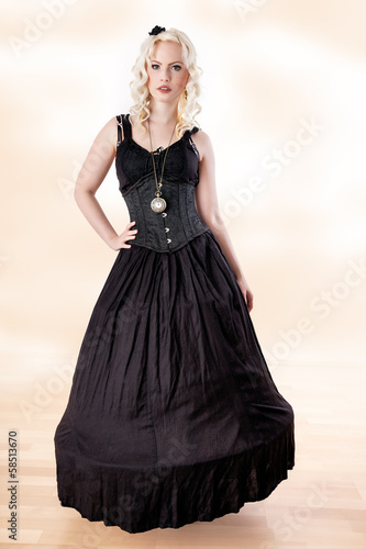 Billede på lærred Woman with curly hair in long black dress