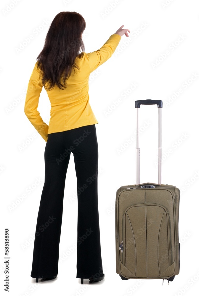 Young traveling woman with suitcas points at wall. Young traveling woman with suitcas points at wall.