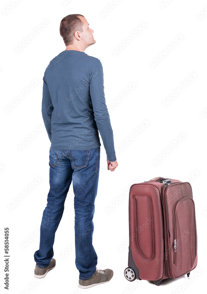 Back view of young man traveling with suitcas. Back view of young man traveling with suitcas.