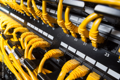 Close-up view on a patch panel with yellow network cables
