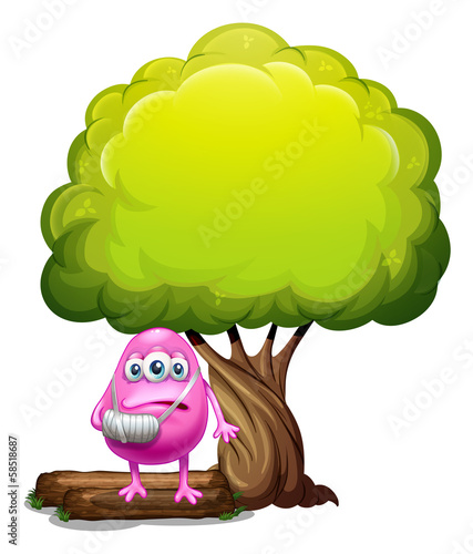 An injured pink beanie monster standing under the giant tree