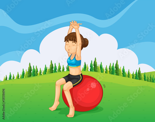 A teenager exercising at the hilltop with a bouncing ball