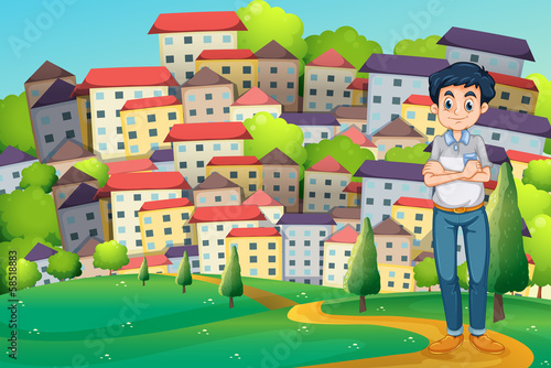 A serious man standing at the hilltop across the village