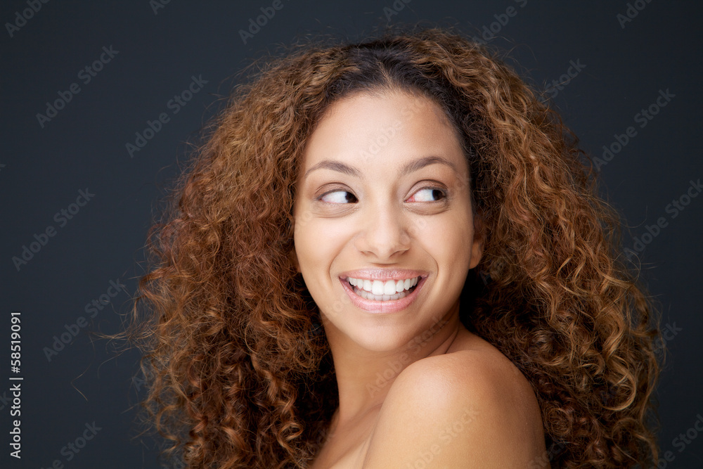 Beautiful young woman with curly hair laughing and looking away Beautiful young woman with curly hair laughing and looking away