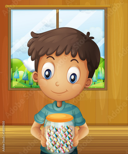 A boy holding a jar of candy balls