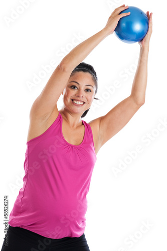 Pregnant woman exercising with weighted ball