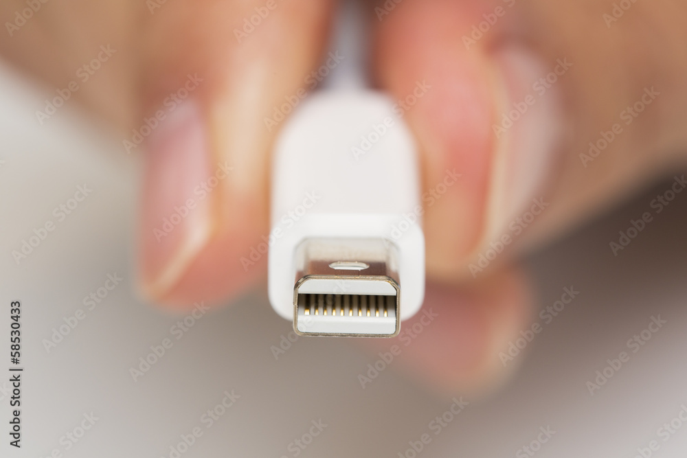 Man's hand holds a Thunderbolt Connector Man's hand holds a Thunderbolt Connector