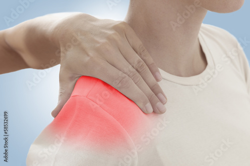 Acute pain in a woman shoulder. Female holding hand to spot of s