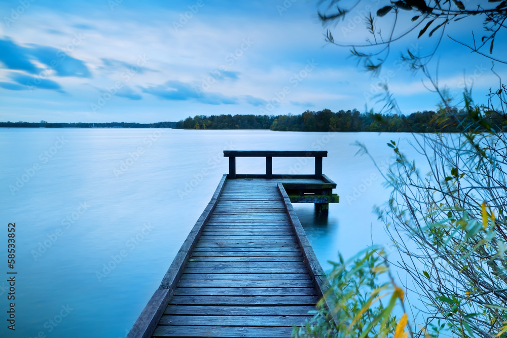 Naklejka premium wooden pier on big lake with long exposure