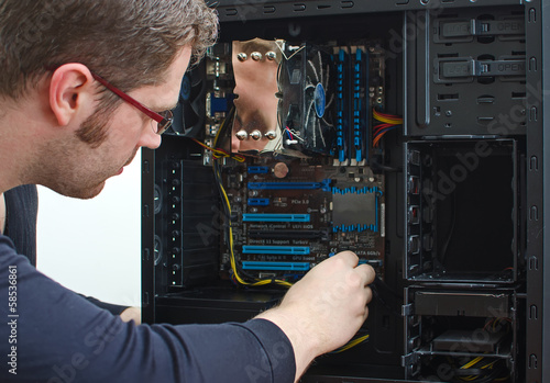 Male technician repairing computer at store