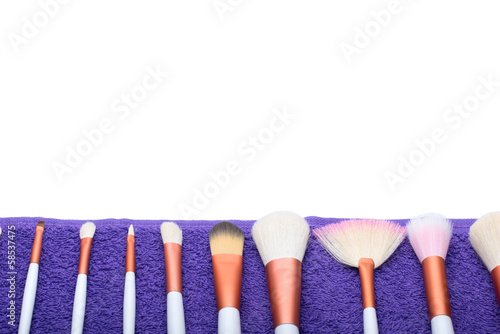Makeup Brushes set on purple towel photo