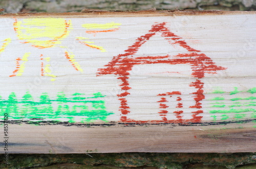Dom narysowany na kawałku drewna