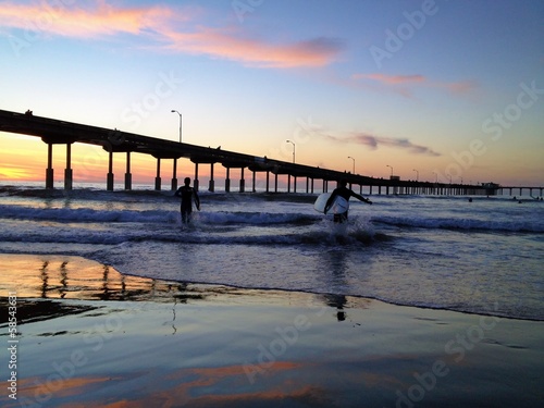 Surfers at Sunset at Ocean Beach Pier San Diego California USA