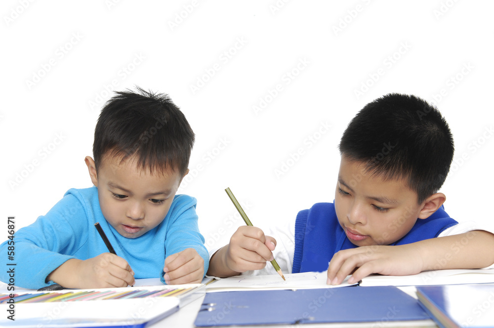 Brother School boy sitting and writing in notebook Brother School boy sitting and writing in notebook