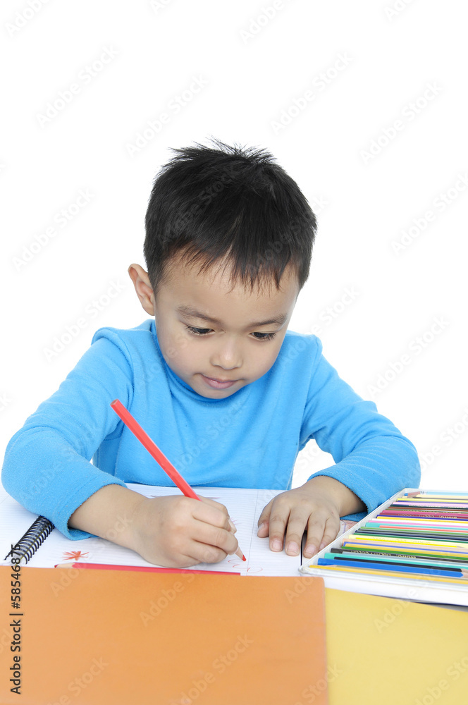 School boy sitting and writing in notebook. School boy sitting and writing in notebook.