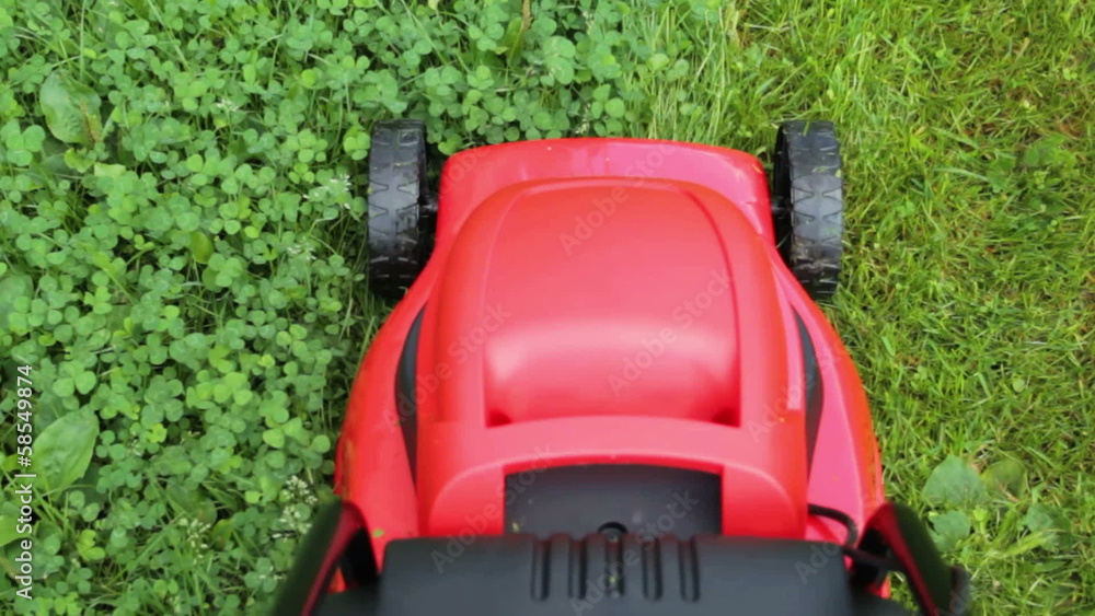 new lawnmower cutting green grass in cloudy day new lawnmower cutting green grass in cloudy day