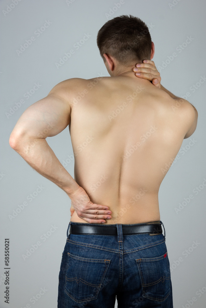 Young man touching his back and neck for the pain