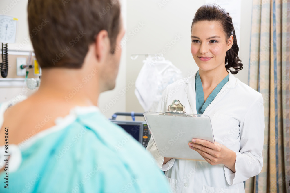 Doctor With Clipboard Smiling At Patient Doctor With Clipboard Smiling At Patient