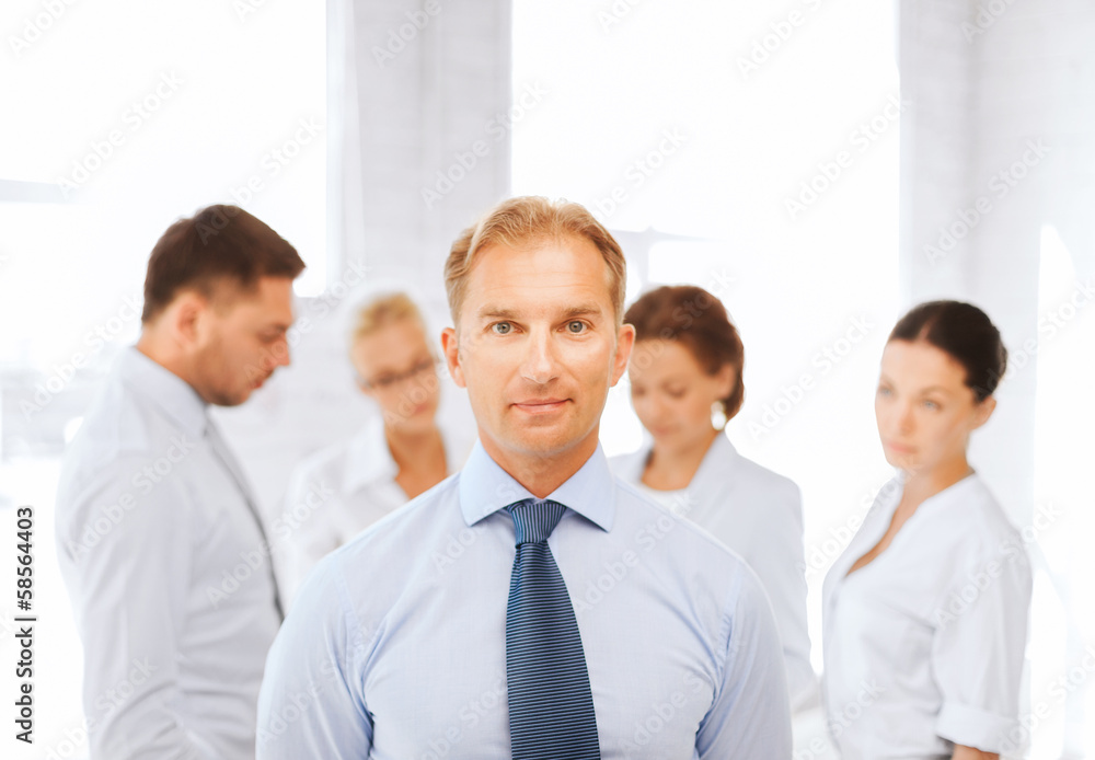 businessman in office with group on the back businessman in office with group on the back