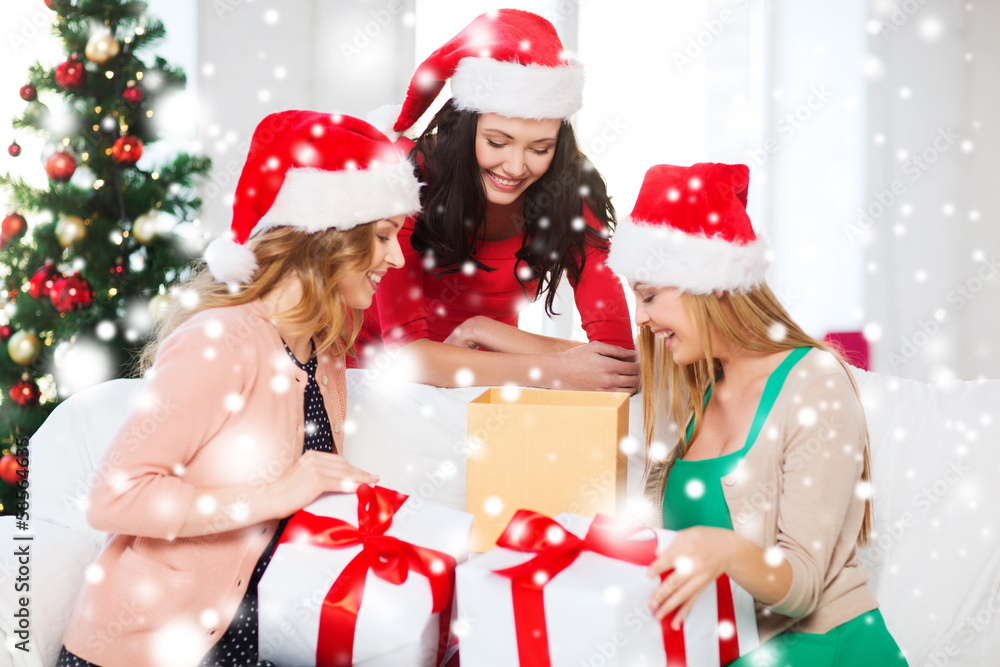 women in santa helper hats with many gift boxes women in santa helper hats with many gift boxes