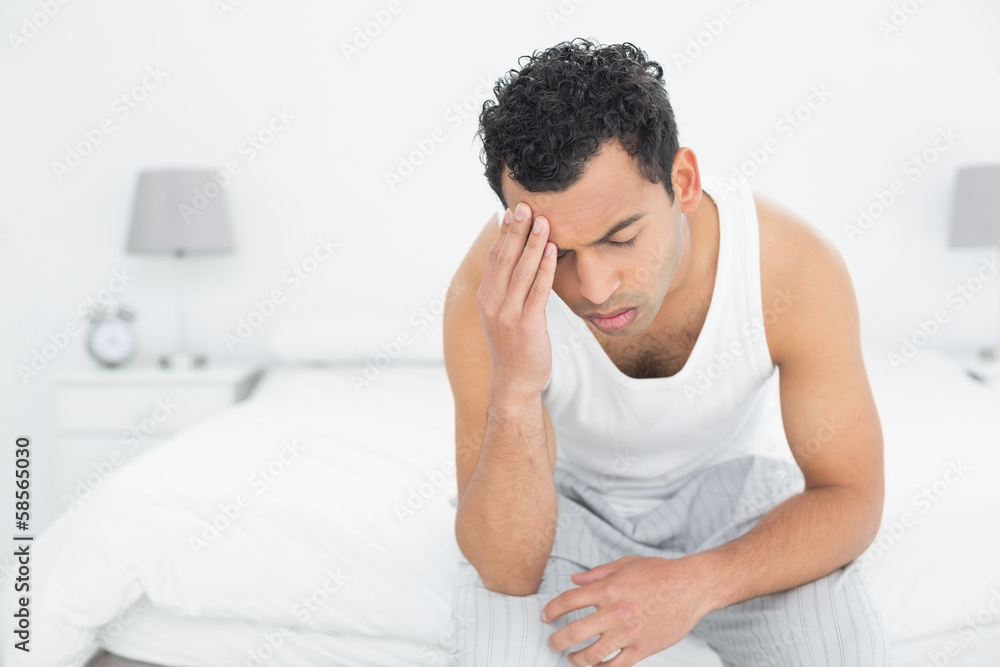 Man suffering from headache in bed Man suffering from headache in bed