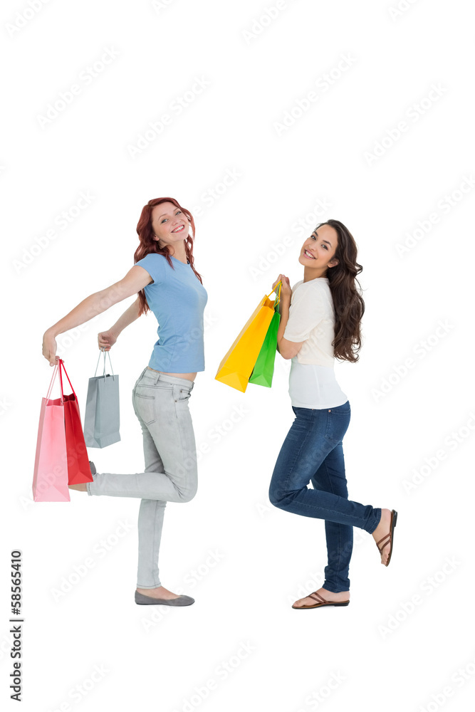 Obraz premium Two happy young female friends with shopping bags
