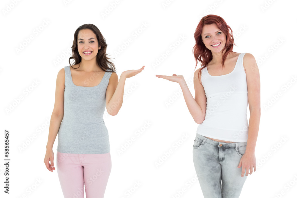 Two happy young female friends holding out their hands Two happy young female friends holding out their hands