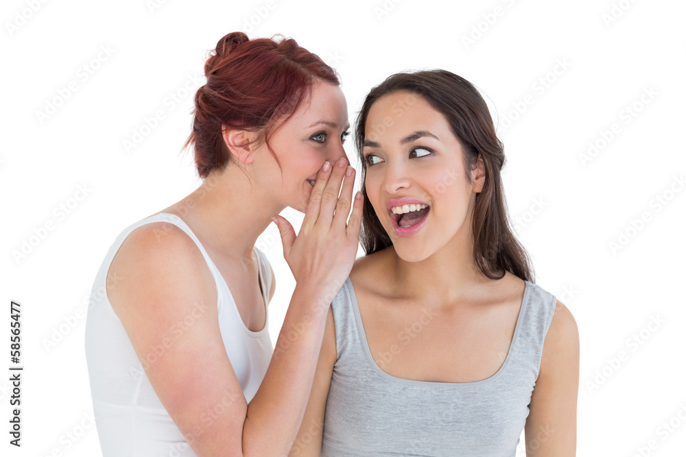 Close-up of two young female friends gossiping Close-up of two young female friends gossiping