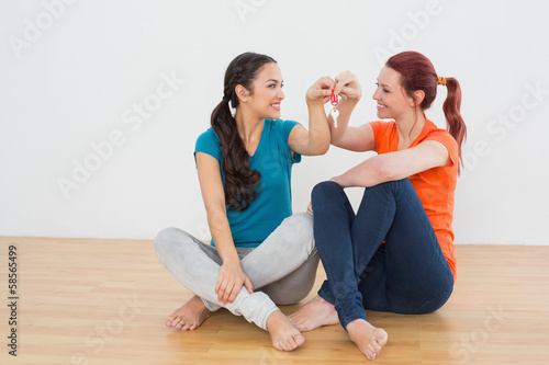 Friends with house keys sitting on the floor