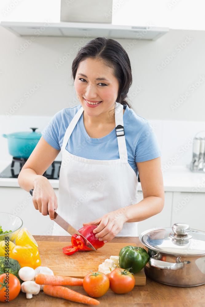 Smiling woman chopping vegetables in kitchen Smiling woman chopping vegetables in kitchen