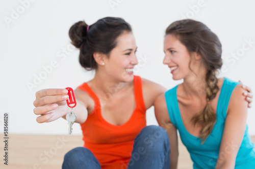 Two cheerful female friends with house keys