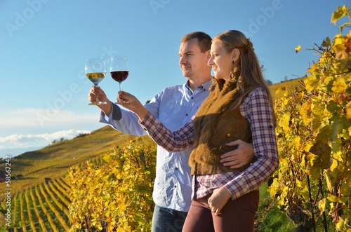 Man and woman tasting wine among vineyards in Lavaux, Switzerlan photo